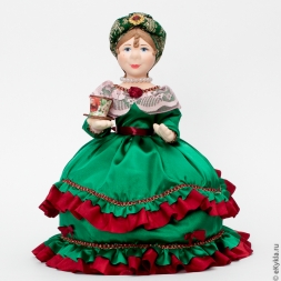 Doll warmer on a teapot with a cup of tea in a green dress